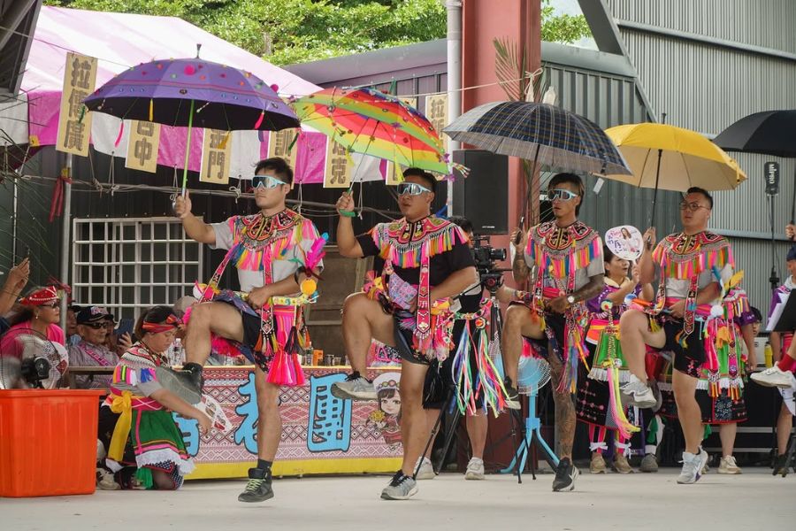 台東のアミ族祭りで飾り傘を持って行進する踊り手たち
