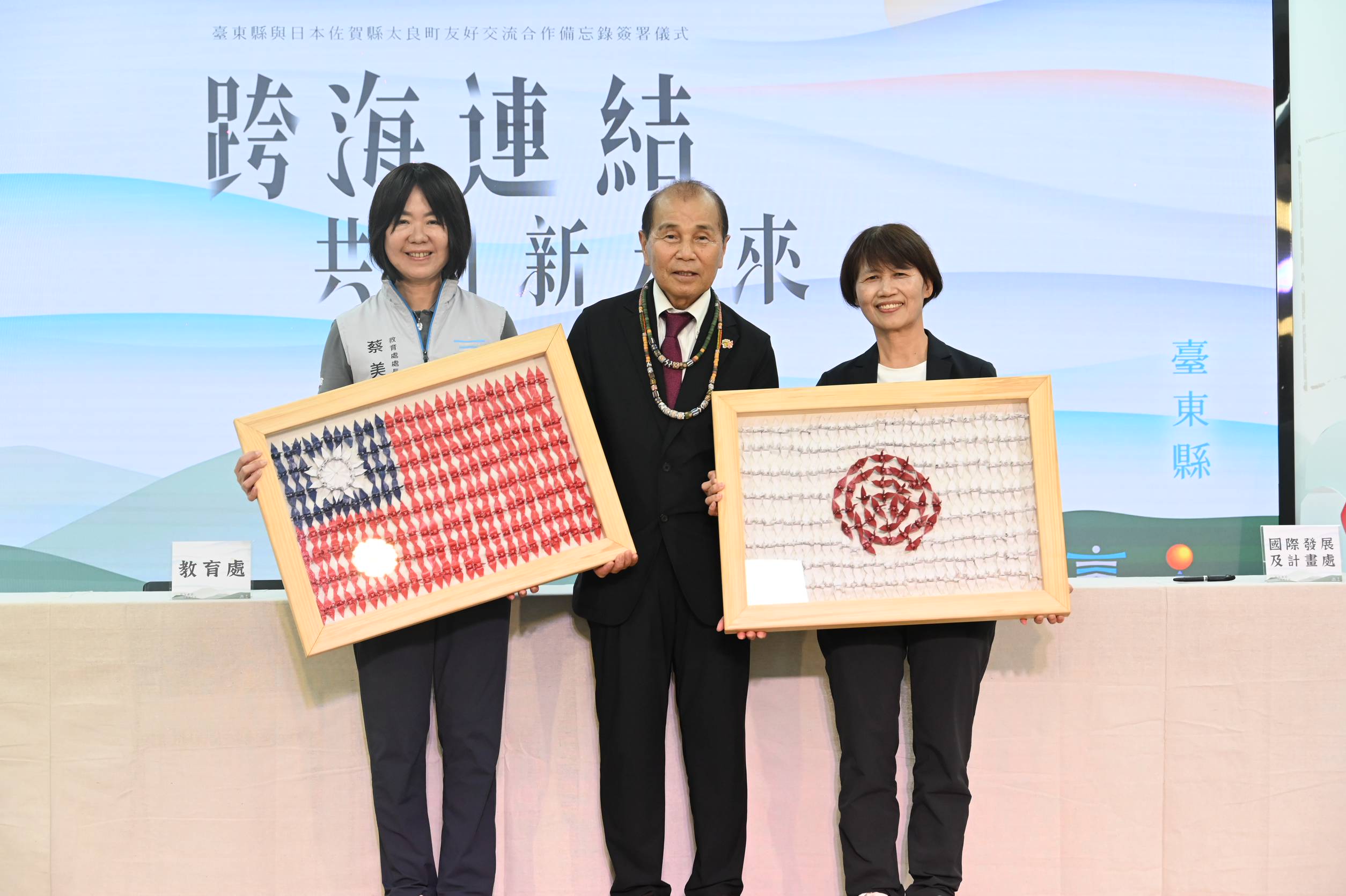 News2 A 調印式後、折り鶴で作った国旗の額を手にする台東県と太良町の代表者たち、2026年8月