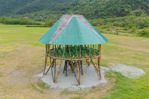 Aerial view of a round bamboo pavilion with a green roof built by an Indigenous community in Taitung