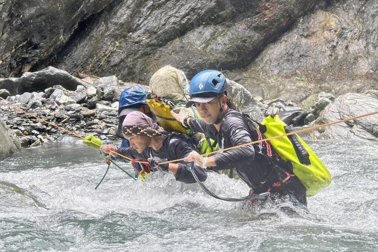 台東の嘉明湖登山で、ロープを使って急流の渓流を渡るガイドたち