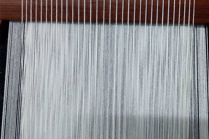Close-up of white warp threads on a traditional Tao backstrap loom